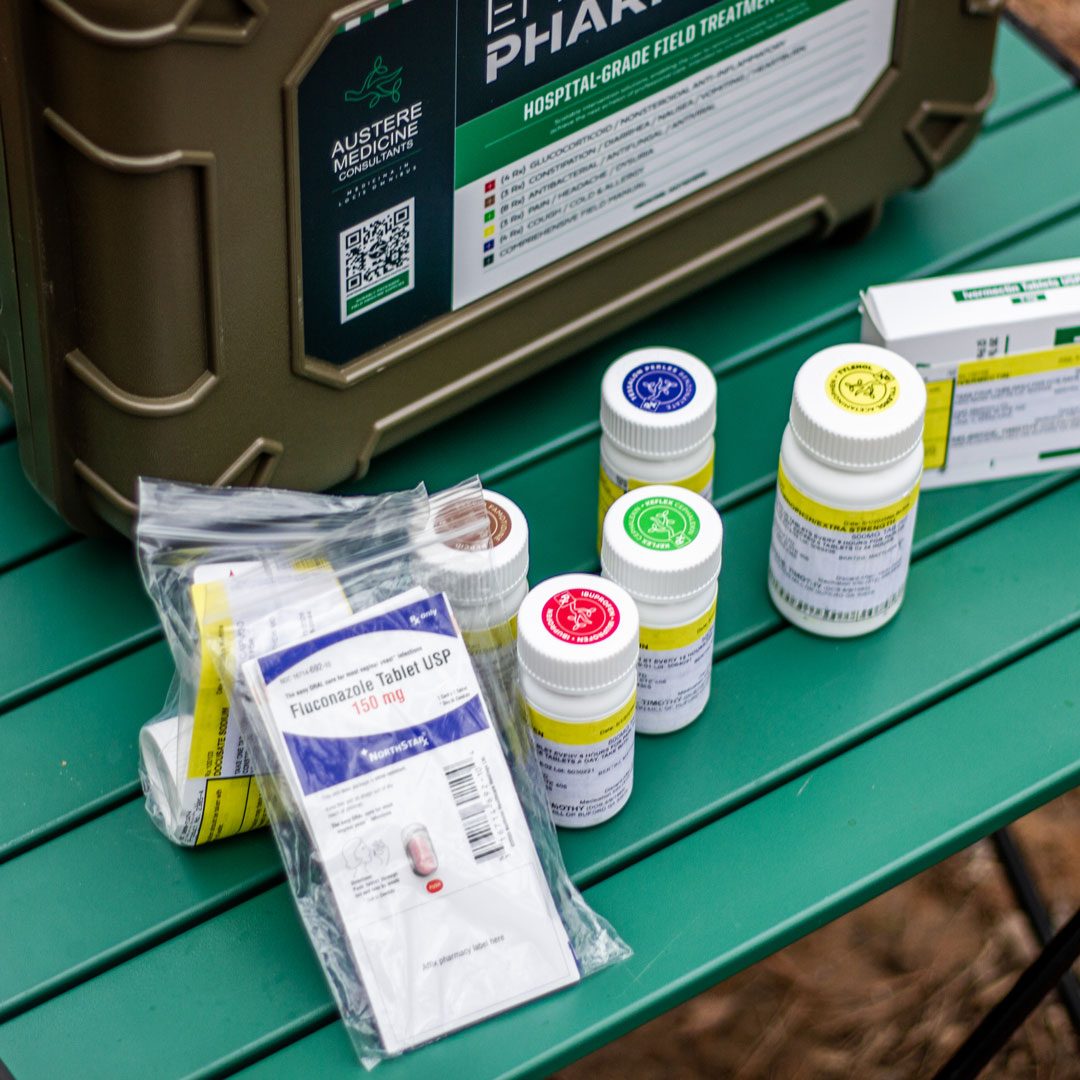 EPFK prescription medication bottles and sealed packs laid out on a camp table