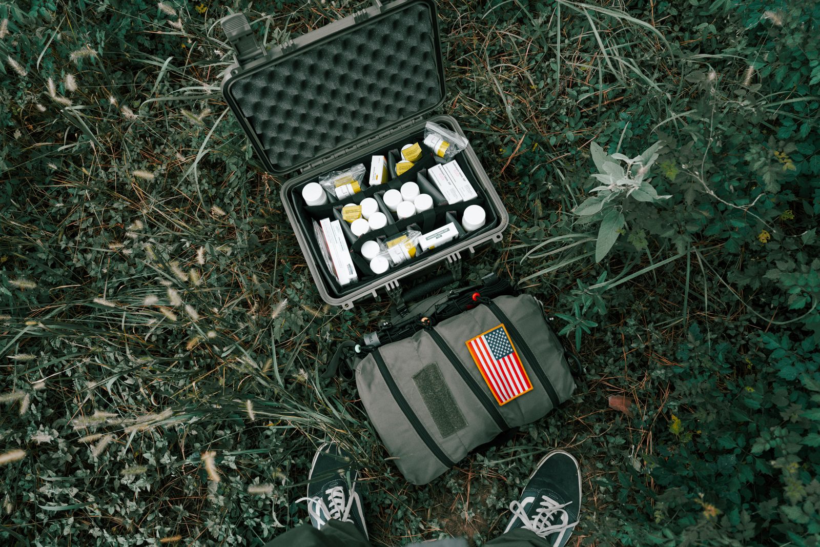 Open EPFK case from above showing organized prescription medication bottles and the field manual